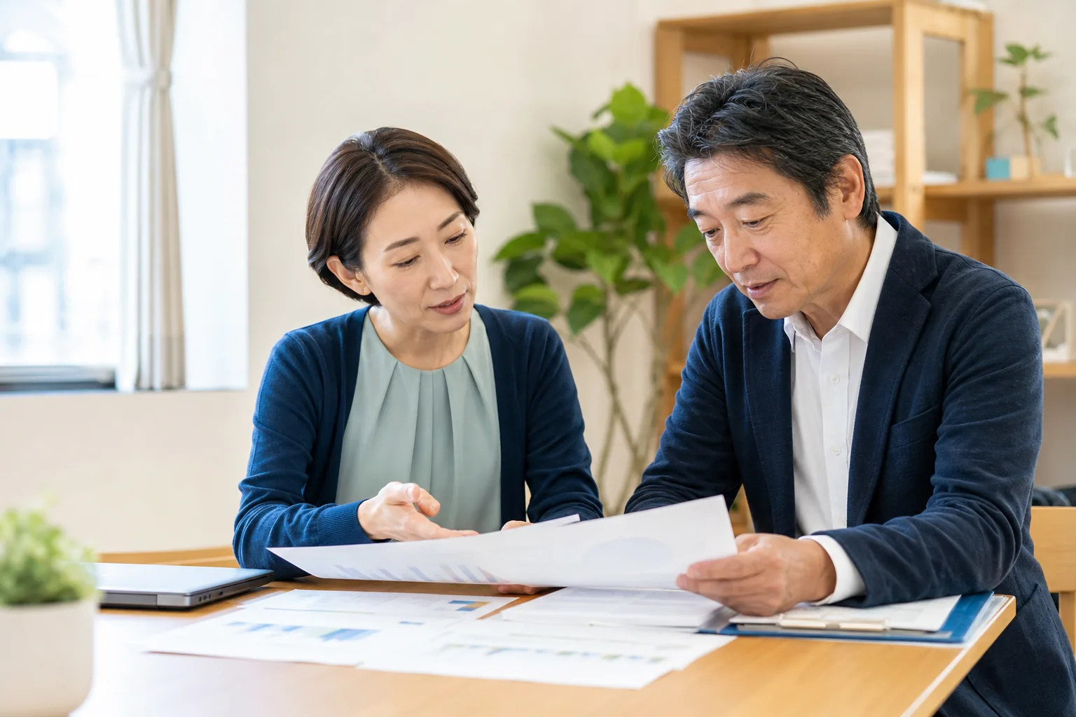 障害福祉事業の運営資料と引継ぎ条件を確認する現場責任者と経営者